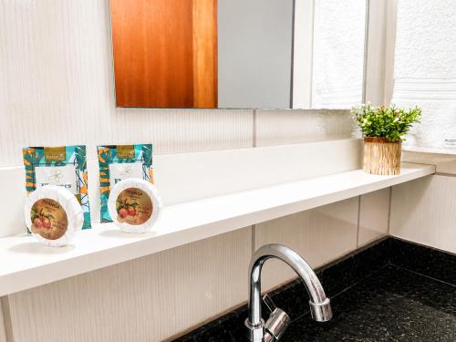 a bathroom counter with a sink and a mirror at Isa Flats in Janaúba