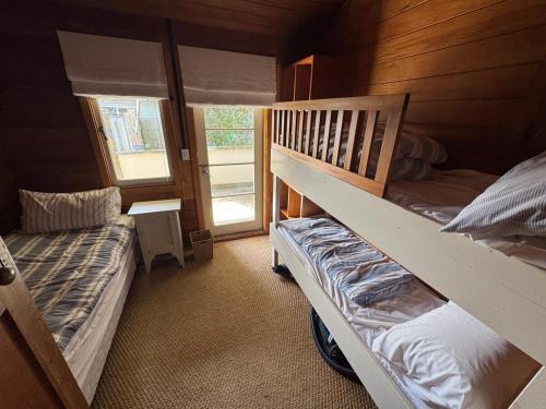 a bedroom with two bunk beds and a window at The Bach - beachfront in Waimarama