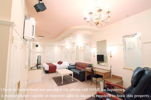 a living room with a couch and a bed at パティオ山梨 - 大人専用 - in Fuefuki