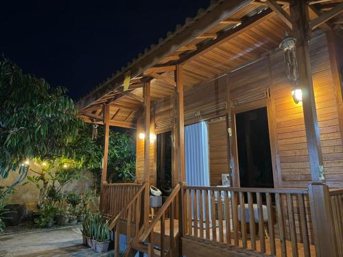a wooden porch of a house at night at Pondok Nisya in Sawan