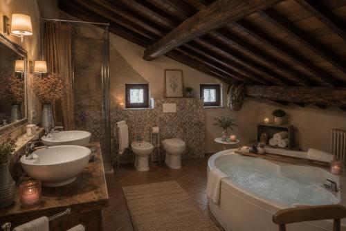 a bathroom with two sinks and a tub and two toilets at LA MORA Exclusive in Moricone