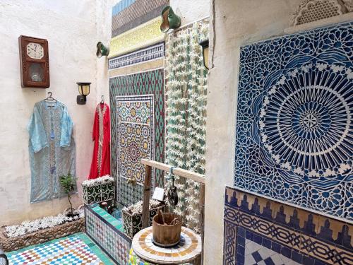 a room with mosaics on a wall with a clock at Hostel Dar Caftan in Fez