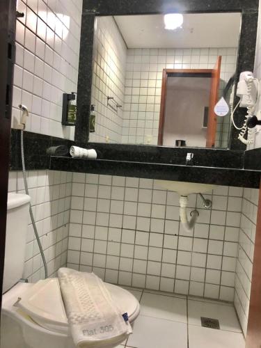 a bathroom with a toilet and a mirror at Ponta Negra Flat 305 in Natal