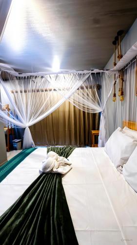 a bedroom with a large white bed with curtains at Pousada Angelim in Santo Amaro