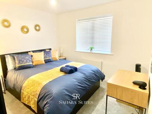 a bedroom with a bed with blue sheets and a window at 4 Bed House with Driveway Parking for 2 Cars - Rugby - Sleeps 10! Perfect for groups! in Rugby