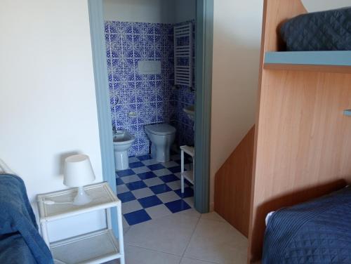 a small bathroom with a toilet and a blue tiled floor at CASA Pitosforo CASA Ulivo in Forio d'Ischia
