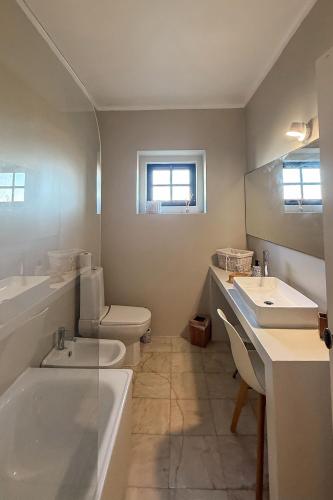 a bathroom with a tub and a toilet and a sink at Casa dos Rebolinhos in Sagres