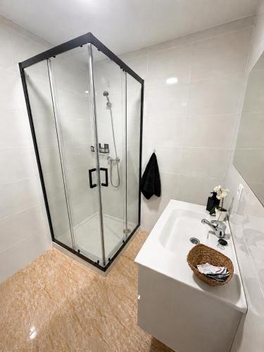 a bathroom with a shower and a white sink at Casa Rural San Gregorio in Alcalá del Júcar