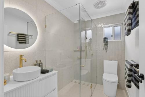 a bathroom with a shower and a toilet and a sink at Boutique Bribie Stay in Bellara