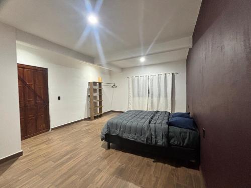 a bedroom with a bed and a wooden floor at Demi Apartment in Zaachila