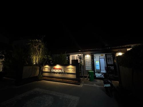 a house with a sign on the side of it at night at Penginapan Angsoka 1 in Singaraja