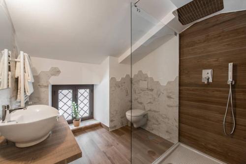 uma casa de banho com um lavatório e uma cabina de duche em vidro. em B&B Glicini em Roma