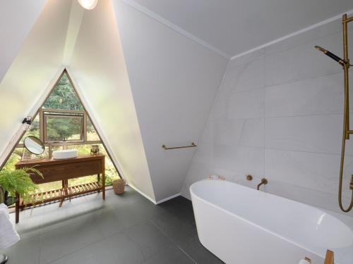 a bathroom with a tub and a sink and a window at Moana View in Paihia