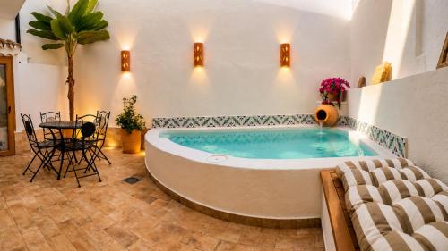 a large tub in a room with a table and chairs at Al Zahra Suites in Zahara de la Sierra
