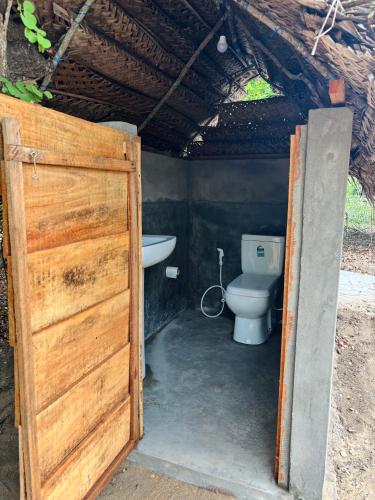 a bathroom with a toilet and a sink at Wana beach camp in Raddela