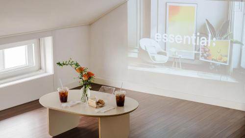 a white room with a table and flowers on it at Chuncheon Rehouse in Chuncheon