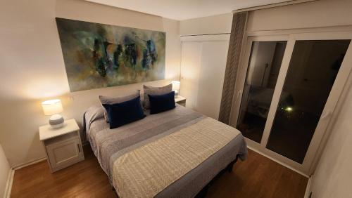 a bedroom with a bed with a painting on the wall at A pasos de Reñaca, Gran Vista in Viña del Mar