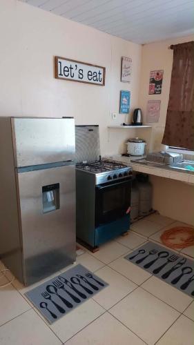 a kitchen with a stove and a refrigerator at Heaiti Lodge in Avatoru