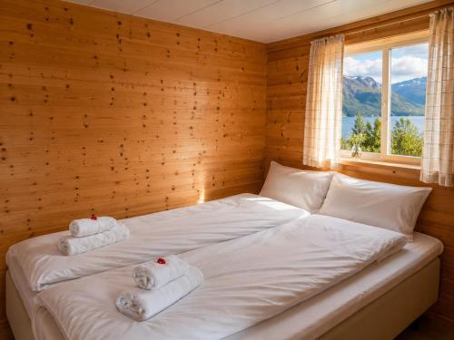 a bed with towels on it in a room with a window at Ryten View Retreat in Hovdan