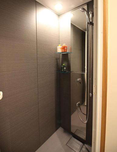 a shower with a glass door in a bathroom at SATOYAMA STAY Nino-Machi in Furukawachō