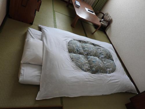 a white pillow on the floor in a room at Ebeotsu Onsen in Takikawa