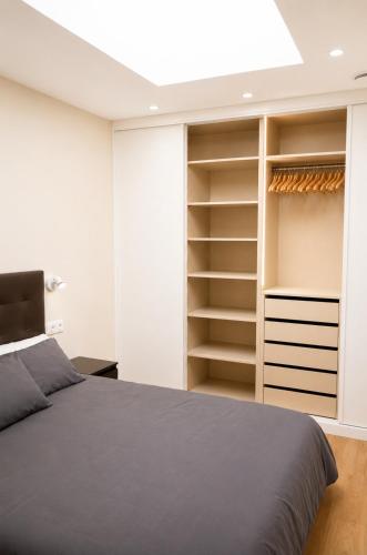 a bedroom with a bed and open closet at Malladoura Passive House in Porriño
