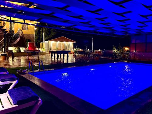 a swimming pool with blue lights in a house at Tuscany Villa Jarash in Al Madwar