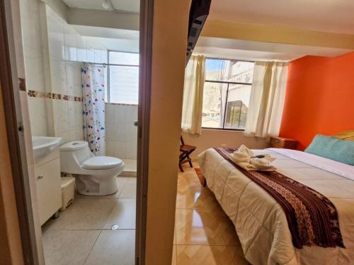 a bedroom with a bed and a bathroom with a toilet at Samaykuy Bed and Breakfast in Urubamba