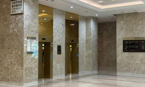 a lobby with two elevators in a building at Centum City Hotel in Busan