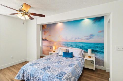 a bedroom with a large painting of the ocean at Downtown Omaha - Elevated Studio & 1-Bed Stays in Omaha