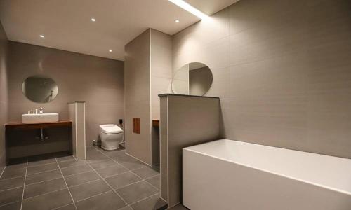 a bathroom with a tub and a toilet and a sink at Dongdaegu Station Eastern Hotel in Daegu