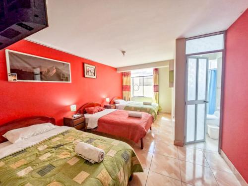 a hotel room with two beds and red walls at Samaykuy Bed and Breakfast in Urubamba