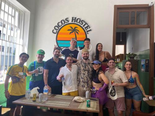 a group of people posing for a picture at a table at Cocos Hostel Rio in Rio de Janeiro