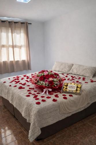 a bed with a bunch of red roses on it at Apartamento em Petrópolis 1 quarto completo in Petrópolis