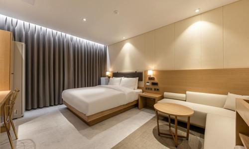 a hotel room with a bed and a couch at Masan Daisy Hotel in Changwon