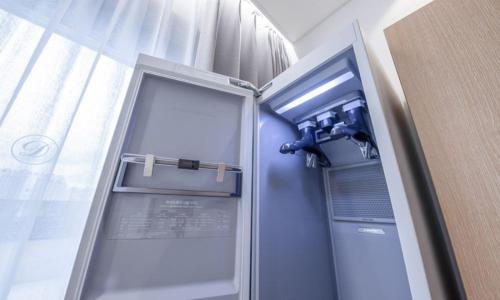 a small refrigerator in a room with a window at Masan Daisy Hotel in Changwon