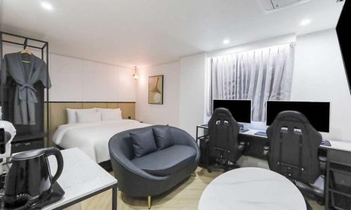 a bedroom with a bed and a chair and a desk at JECHEON No 25 HOTEL in Jecheon