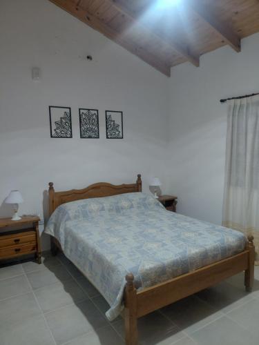 a bedroom with a wooden bed and a night stand at Quinta Los Sauces in Nueve de Julio