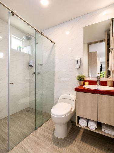 a bathroom with a toilet and a glass shower at Piedra Luna in Cali