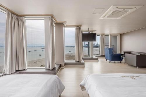 a bedroom with two beds and a view of the ocean at Dangjin Hotel IVAN in Dangjin