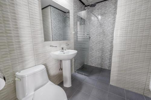 a white bathroom with a toilet and a sink at Dangjin Hotel IVAN in Dangjin