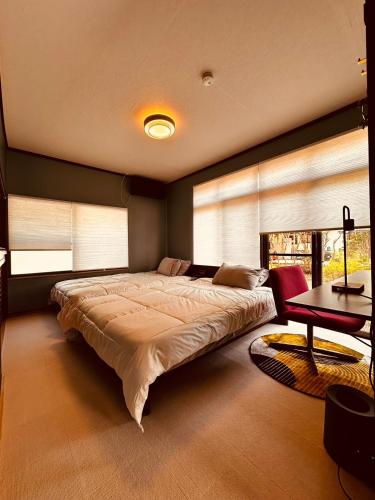 a bedroom with a large bed and a table at IPPONMATSU Private Villa - 宮崎の古民家一棟貸し 一本松 in Miyazaki