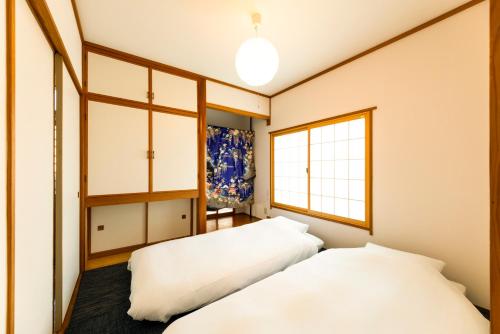 two beds in a room with a window at kagoshima take in Kagoshima