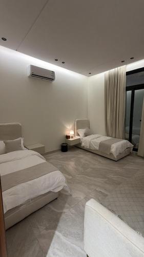 a bedroom with two beds and a window at Velora Suites in Abha