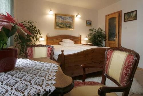 a bedroom with a bed and two chairs and a table at Apartmány ReMi Vysoké Tatry in Smokovce
