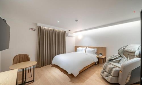 a hotel room with a bed and a table and a chair at Brown Dot Hotel NamGumi in Yangji-mal