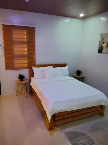 a bedroom with a white bed with two tables at Nord House Laoag 7 in Laoag
