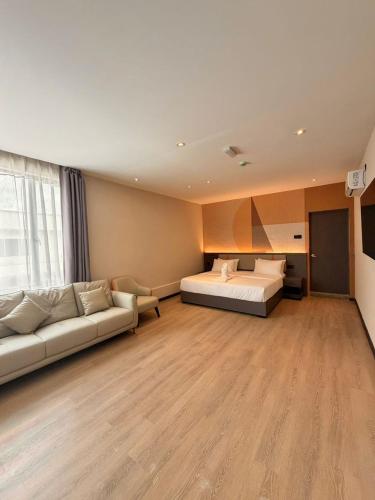 a large room with a bed and a couch at I Fly Hotel BSI in Tawau
