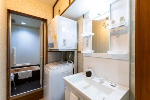 a small bathroom with a sink and a washing machine at kagoshima take in Kagoshima
