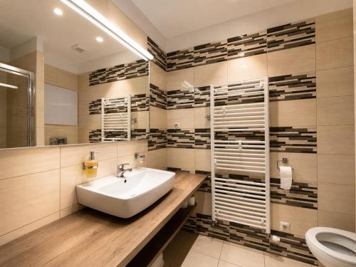 a bathroom with a sink and a toilet at Apartment Elegance Hrebienok in Starý Smokovec